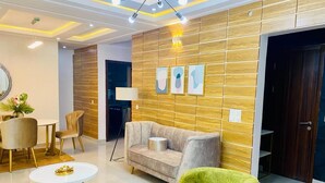 Un salon moderne avec un canapé, un fauteuil vert et une table basse ronde.