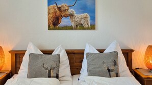 A hotel room with two beds, a painting of a cow and a dog, and a woven light fixture above the beds. - Penthouse Summer & Winter Fun 4, roof terrace (Zell am See)