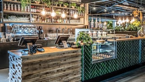 A bar area with a wooden counter, bar stools, and shelves stocked with bottles and glasses. - Lodge in Schaijk Near Green Forests (Schaijk)