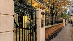 Un lotissement résidentiel fermé, délimité par un mur de briques et une porte en métal.