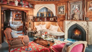 Une pièce de style traditionnel, dotée d’une cheminée, d’un canapé, d’un fauteuil de lecture et d’une bibliothèque.