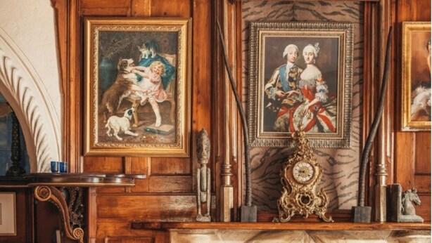 Une pièce de style traditionnel, dotée d’une cheminée, de boiseries et d’œuvres d’art encadrées qui ornent les murs.