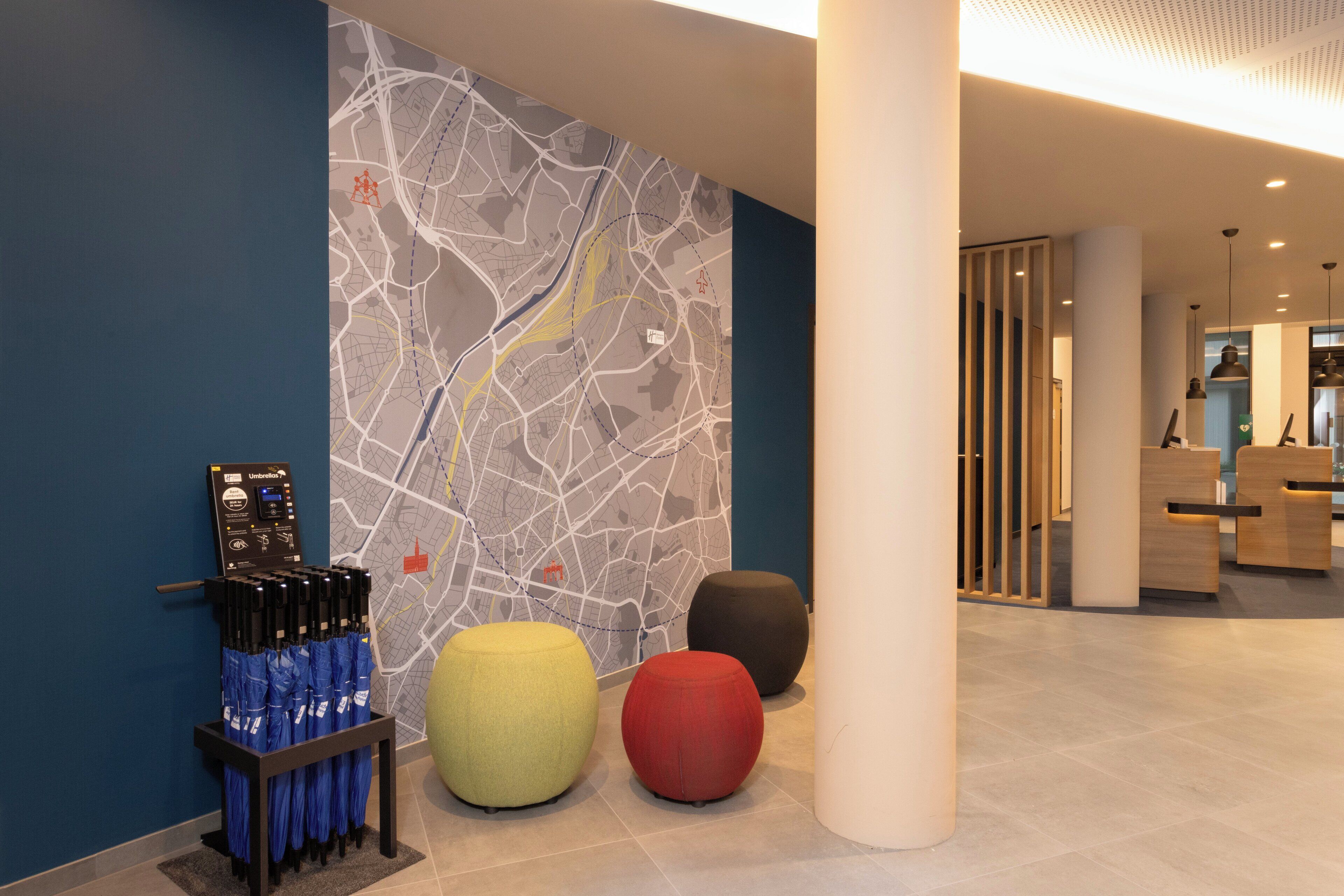 A modern lobby with a map mural, a bench area, and a reception desk.