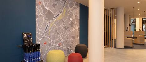 A modern lobby with a map mural, a bench area, and a reception desk.