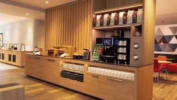 Uma estação de café moderna com bancada de madeira, máquinas de café e diversas embalagens de café.