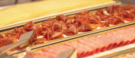 Un bufé con diversas carnes y quesos.