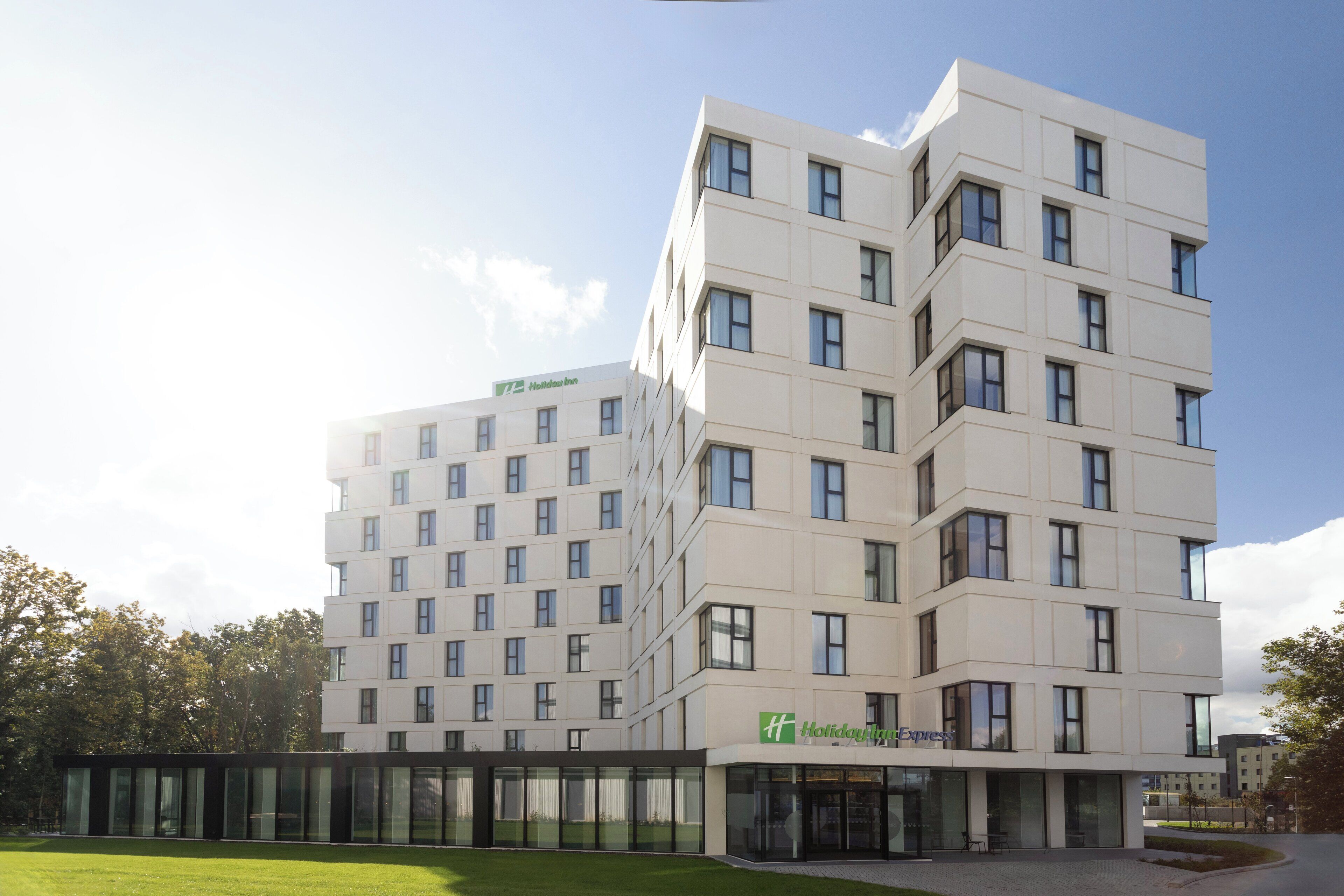 A modern hotel building with multiple floors, large windows, and a visible Holiday Inn Express sign.