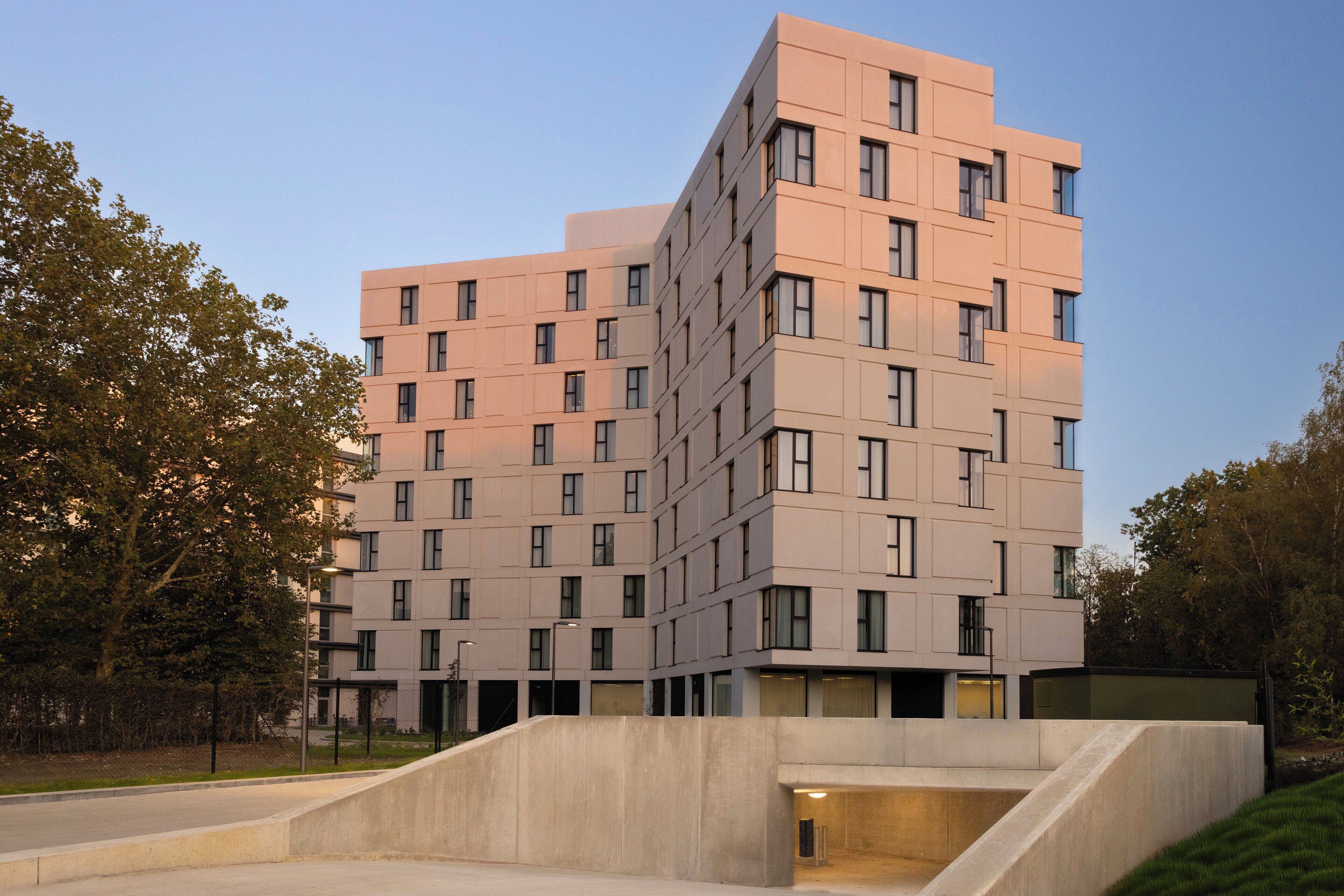 A multi-story building with a modern architectural design, featuring a series of balconies and large windows.