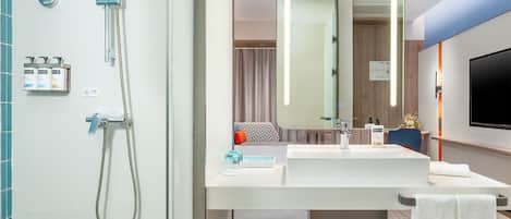 A modern bathroom with a shower, sink, and mirror.