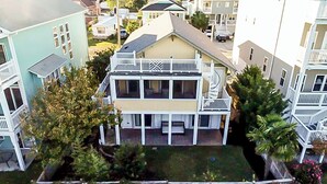 Ein zweistöckiges Haus mit Balkon, umgeben von anderen Häusern.