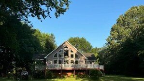A large house with a balcony, surrounded by a well-maintained lawn and trees. - Relax & enjoy the river view, 5 min to Huntsville (Laceys Spring)