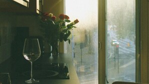 A kitchen with a large window, a vase with flowers, and a glass of water on the counter. - London Gem - Chic Apartment Retreat (London)