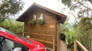 Una cabaña de madera con balcón y un letrero que dice "MORADA DOS TUCAOS".