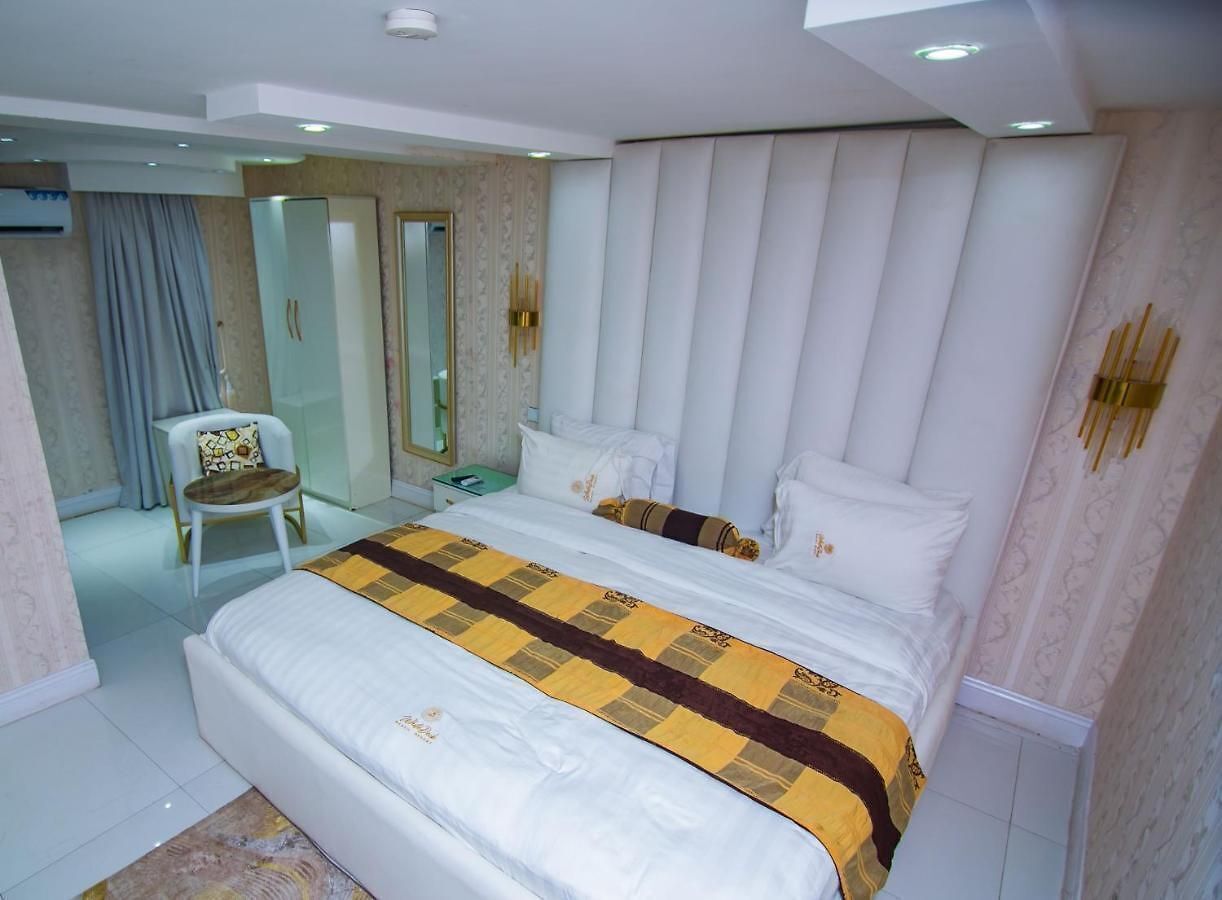 A modern hotel room with a large bed, a chair, and a mirror.