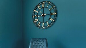 A teal wall with a large black clock featuring Roman numerals and a diamond pattern. - Spacious 3 Bedroom Home in Guisborough (Redcar and Cleveland)