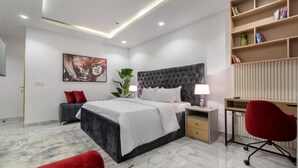 A modern bedroom with a large bed, bedside tables, a desk, and a bookshelf. - W16 Waterfront Hotel and Apartments (Lekki)
