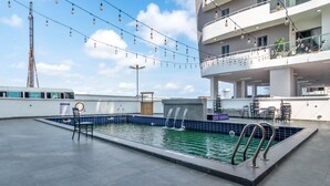 A rooftop pool with a blue tiled edge, surrounded by a spacious terrace with outdoor furniture. - W16 Waterfront Hotel and Apartments (Lekki)