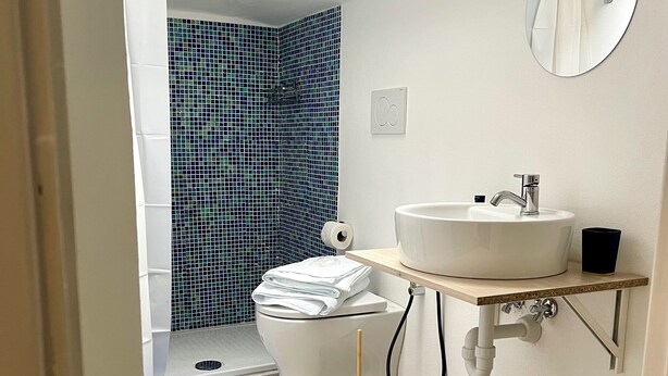 A modern bathroom with a toilet, sink, and shower area. - La Casa al Mare (Alassio)