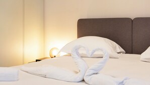 Een hotelkamer met een net opgemaakt bed, een hoofdbord en een bedlampje.