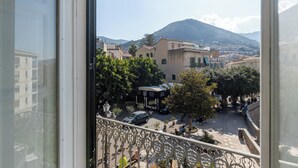 A balcony with a view of a town square, buildings, and a mountain in the distance. - Eleganza in Centro a Cefalù by Wonderful Italy (Cefalù)