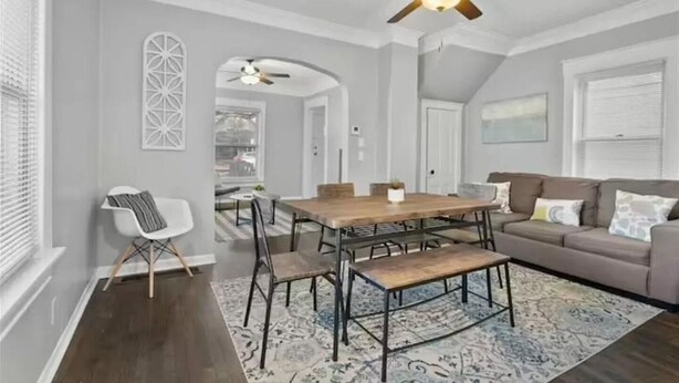 A dining area with a wooden table, chairs, and a ceiling fan. - Experience KC from Twin Bells: Two Charming Bungalows, One Prime Location! (Kansas City)