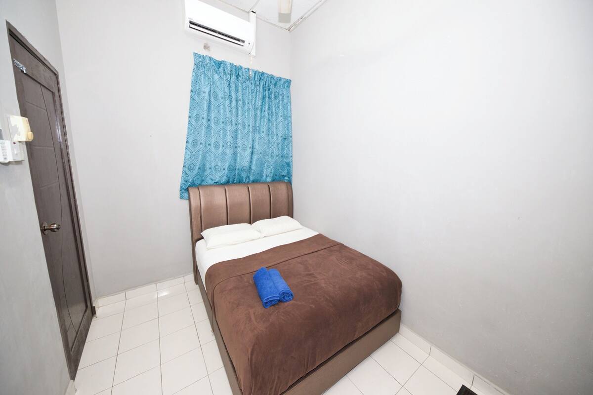Ein Schlafzimmer mit einem Bett, einer Tür und einer Klimaanlage.