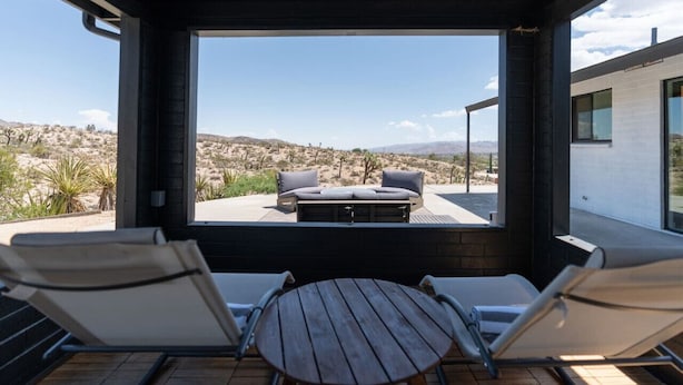 Un área de estar moderna al aire libre con vistas a un paisaje desértico.