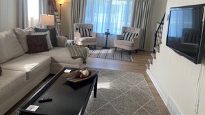 A living room with a sofa, armchairs, a coffee table, and a TV. - Pet-friendly, Kid-friendly Farmhouse near Holy Hill, Ice Age Trail, State Forest (Hubertus)