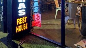 A restaurant named 'BANANAS REST HOUSE' with a neon sign, a 'No Parking' sign, and a view of the interior including a dining area and a bar. - Banaras Rest House  (Varanasi)