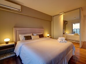 Relax in comfort with a large bed, bedside table, and mirror.