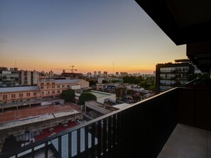 Enjoy breathtaking city views from this high-rise balcony with a metal railing and tiled floor.
