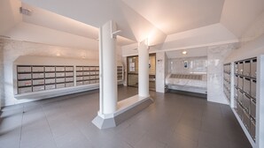 Ein modernes Interieur mit Marmorwänden, einer zentralen Säule und Ablagekörben.