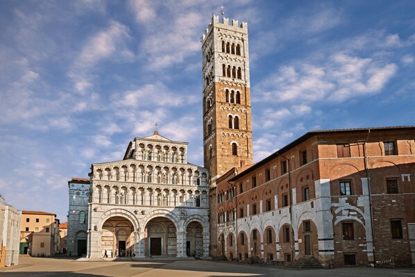 A historic building with a prominent tower and arched entrances. - Appartamento Le Mimose In Lucca (Lucca)