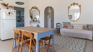 A compact living space with a dining area, kitchenette, and a sofa set. - Villetta al Plemmirio by Wonderful Italy (Syracuse)