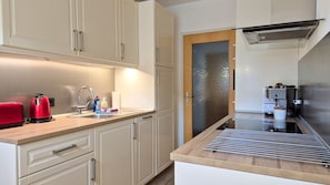Une cuisine moderne équipée d’une cuisinière intégrée, d’un évier et d’un grille-pain.