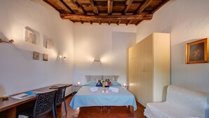 Ein Schlafzimmer mit einem Bett, Nachttischen, einem Schreibtisch und Stühlen.