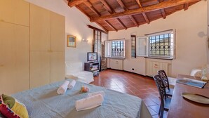 Ein Zimmer mit einem Bett, einem Schreibtisch, einem Fernseher und einem Fenster mit Gitterstäben.