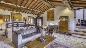 A spacious room with a high wooden ceiling, a leather sofa, a wooden coffee table, and a large mirror. - Casale Al Sole Tra Le Vecchie Vigne 6 (Radda in Chianti)
