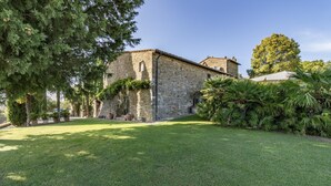 A stone building with a well-maintained lawn and surrounding greenery. - Casale Al Sole Tra Le Vecchie Vigne 6 (Radda in Chianti)
