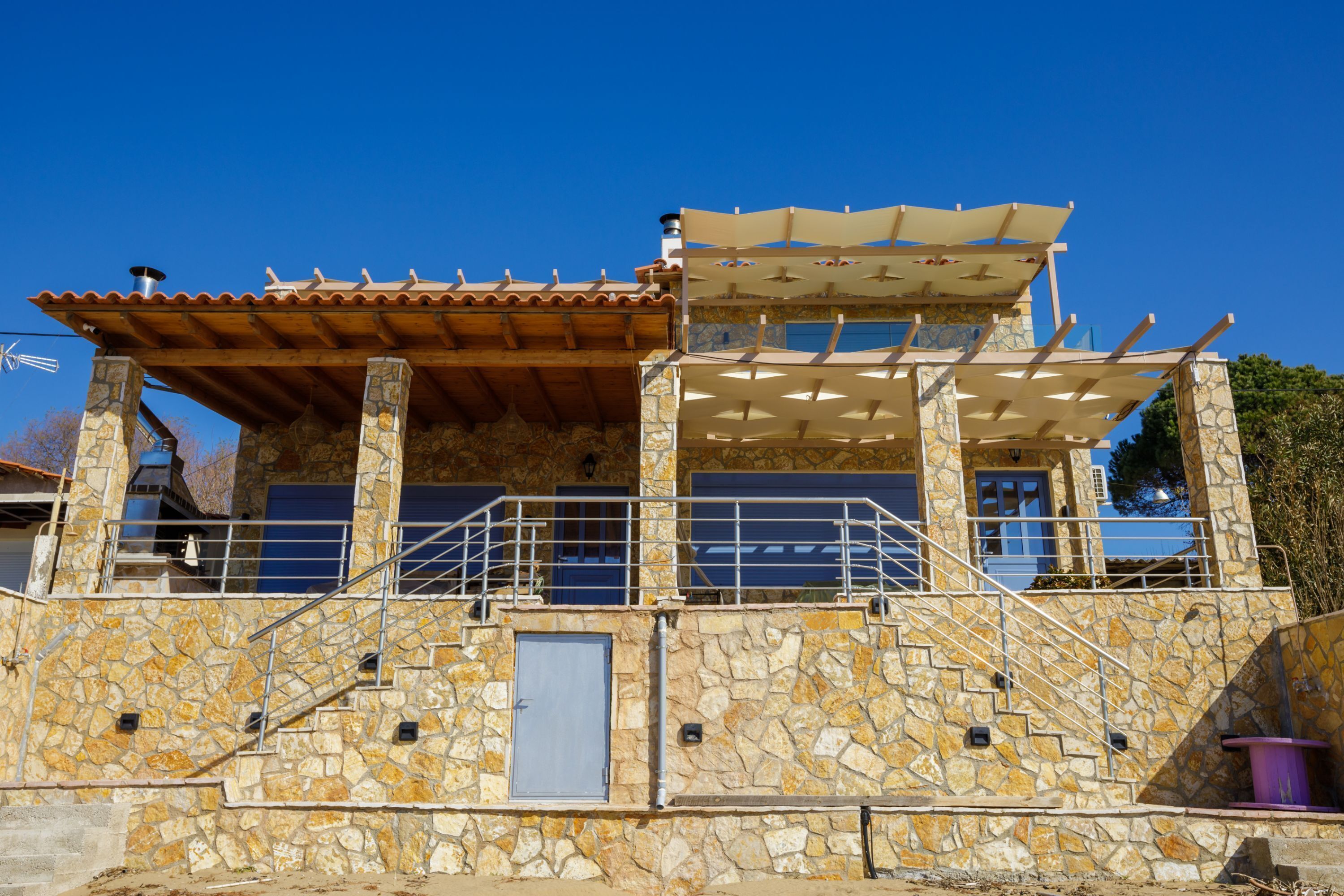 A stone building with a wooden roof and a covered patio area.