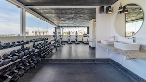 Ein Fitnessstudio mit Kurzhanteln, Laufbändern und Kraftgeräten.