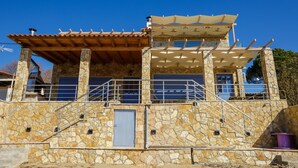 Un edificio in pietra con tetto in legno e una veranda coperta.