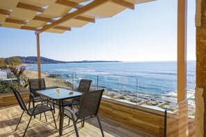 A terrace with a table and chairs overlooking the sea. - Maritinas Apartment Sea View (Pyrgos)