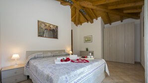 A bedroom with a bed, nightstand, lamp, and a wooden ceiling. - Le Betulle Garden in Laveno (Laveno Mombello)