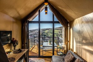 A cozy room with a large window, a wooden ceiling, and a view of the countryside. - Moose Cabin With A Panoramic View (Hosszúhetény)