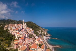 A coastal town with historic buildings, a prominent church tower, and a beach.