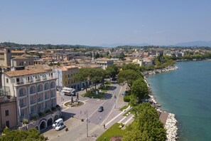 Paesaggio costiero urbano con un edificio importante con balconi e una passeggiata sul lungomare.