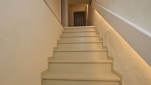 Una scala con un corrimano sulla destra e una porta in cima.