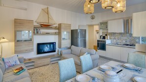 Ein modernes Wohnzimmer mit Sofa, Fernseher und Essbereich.
