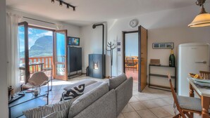 Ett modernt vardagsrum med en soffa, ett matbord och en köksdel.